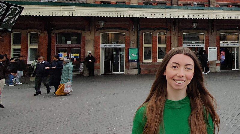 Chelsea Whyte, Slough Lib Dem Parliamentary Candidate, in front of Slough Train Station
