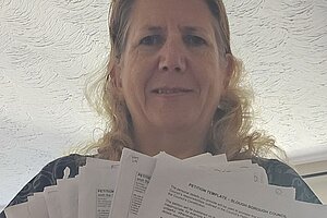 Jen Simpson with paper copies of the petition