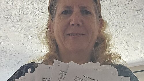 Jen Simpson with some of the 1,700 signatures on the petition she led